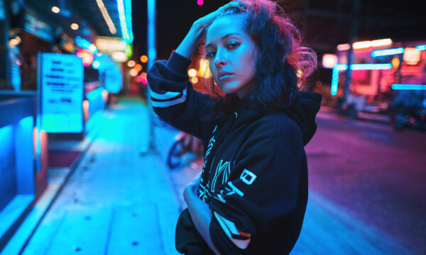 Neon close up portrait of young beautiful woman wear hoodie. night city street shot